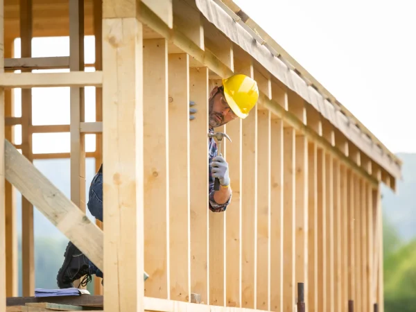 builder-working-on-wooden-construction-of-frame-ho-2024-10-30-22-22-58-utc